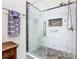 Modern glass shower with river rock floor, tiled walls, and built in shelving at 649 Meadow Pointe Dr, Haines City, FL 33844