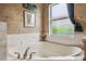 Bathroom featuring a soaking tub and window with natural light at 651 Highlands Hammock Dr, Poinciana, FL 34759