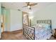 Cozy bedroom with soft carpet, ceiling fan, doorway to bathroom, light green walls, and decorative metal bed frame at 651 Highlands Hammock Dr, Poinciana, FL 34759