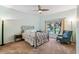 Cozy bedroom with soft carpet, ceiling fan, doorway to bathroom, light green walls, chair, and decorative metal bed frame at 651 Highlands Hammock Dr, Poinciana, FL 34759