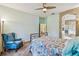 Cozy bedroom with soft carpet, ceiling fan, doorway to bathroom, light green walls, and decorative metal bed frame at 651 Highlands Hammock Dr, Poinciana, FL 34759