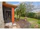 Exterior view of the home featuring a screened-in lanai, stone pavers and tropical landscaping, with green lawns at 651 Highlands Hammock Dr, Poinciana, FL 34759