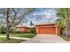 Charming one-story home with a brick driveway, lush lawn, and meticulously maintained landscaping at 651 Highlands Hammock Dr, Poinciana, FL 34759