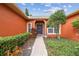 Inviting front entrance with a brick walkway, manicured bushes, and an elegant door at 651 Highlands Hammock Dr, Poinciana, FL 34759