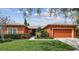 Attractive home featuring a well-kept lawn, tasteful landscaping, and a brick-paved driveway at 651 Highlands Hammock Dr, Poinciana, FL 34759