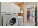 Bright laundry room with a modern washer, dryer, and overhead cabinets at 651 Highlands Hammock Dr, Poinciana, FL 34759