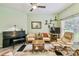 Comfortable living area with a piano, sofa, armchairs, and a ceiling fan at 651 Highlands Hammock Dr, Poinciana, FL 34759