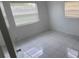 This bedroom features a white-tiled floor and two windows with white blinds at 717 Michigan Ct # 2, St Cloud, FL 34769