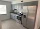 This kitchen features gray cabinets, stainless steel appliances, and light gray flooring at 717 Michigan Ct # 2, St Cloud, FL 34769