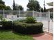View of community pool enclosed by a white fence and a green hedge at 717 Michigan Ct # 2, St Cloud, FL 34769