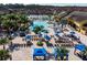 Expansive aerial view showcasing the beautiful community pool, seating area, and surrounding lush landscaping at 8974 California Palm Rd, Kissimmee, FL 34747