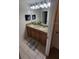 Well-lit bathroom features double sinks with granite countertop, decor and tile flooring at 8974 California Palm Rd, Kissimmee, FL 34747