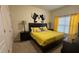 Bedroom with a black headboard, yellow bedding, and bright, natural light at 8974 California Palm Rd, Kissimmee, FL 34747