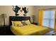 Bedroom with a black headboard, yellow bedding and Mickey Mouse wall decor at 8974 California Palm Rd, Kissimmee, FL 34747