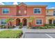 Charming townhouse featuring a terracotta-colored facade, arched doorways, and lush landscaping at 8974 California Palm Rd, Kissimmee, FL 34747