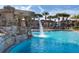 Resort-style pool with rock waterfall and palm trees creating a tropical oasis for residents to enjoy at 8974 California Palm Rd, Kissimmee, FL 34747