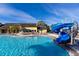 Large community pool with a blue slide and a waterfall feature, perfect for Gathering fun in the sun at 8974 California Palm Rd, Kissimmee, FL 34747