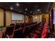 Home theater room featuring tiered seating and a large projection screen at 8974 California Palm Rd, Kissimmee, FL 34747