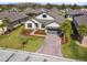 Aerial view of a single-Gathering home with a brick driveway, manicured lawn, and mature landscaping at 937 Walnut Creek Ln, Poinciana, FL 34759