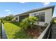 Exterior rear view showcasing a landscaped yard with a partial fence and screened patio at 937 Walnut Creek Ln, Poinciana, FL 34759