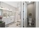 Bathroom featuring a double vanity, glass-enclosed shower, and adjacent toilet with enhanced accessibility at 937 Walnut Creek Ln, Poinciana, FL 34759