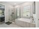 A luxurious bathroom featuring a glass-enclosed shower, soaking tub, and modern fixtures at 937 Walnut Creek Ln, Poinciana, FL 34759