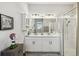 Elegant bathroom with double sink vanity, modern fixtures, a glass-enclosed shower, and ample cabinet space at 937 Walnut Creek Ln, Poinciana, FL 34759