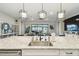 Kitchen island showcasing granite countertops, stainless steel sink and a view to the living area and outdoor patio at 937 Walnut Creek Ln, Poinciana, FL 34759