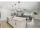 Open concept living area featuring a kitchen island, granite countertops, and stylish lighting fixtures at 937 Walnut Creek Ln, Poinciana, FL 34759