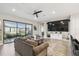 Open living room with a large sofa, neutral walls, and a sliding glass door to the patio at 937 Walnut Creek Ln, Poinciana, FL 34759