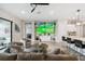 Bright living room featuring modern decor, a large TV, and an open layout to the kitchen at 937 Walnut Creek Ln, Poinciana, FL 34759