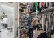 Walk-in closet featuring organized storage with custom shelving and hanging rods; easy access to the en-suite bathroom at 937 Walnut Creek Ln, Poinciana, FL 34759
