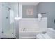 Bathroom featuring a glass shower, soaking tub, white tiled walls, and modern fixtures at 1113 Pine Ridge Dr, Davenport, FL 33896