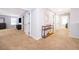 Hallway with neutral carpet, an ornate display table, and access to multiple rooms at 1113 Pine Ridge Dr, Davenport, FL 33896