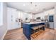 Modern kitchen boasts a central island with seating, stainless steel appliances, and white cabinetry at 1113 Pine Ridge Dr, Davenport, FL 33896