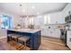 Well-lit kitchen featuring an island with seating, white cabinets, and stainless steel appliances at 1113 Pine Ridge Dr, Davenport, FL 33896