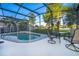 Enclosed pool area with patio furniture and a serene backyard view at 1113 Pine Ridge Dr, Davenport, FL 33896