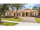 Elegant home featuring a tile roof, arched entryway, three-car garage, landscaped front yard and brick paved driveway at 11856 Vinci Dr, Windermere, FL 34786