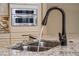 Close up of a Kitchen sink with granite countertops, tiled backsplash, and stainless steel faucet at 11856 Vinci Dr, Windermere, FL 34786