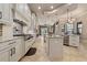 Open concept kitchen with white cabinets, stainless steel appliances, island, and views to the living area at 11856 Vinci Dr, Windermere, FL 34786