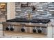 Stainless KitchenAid stove top and pot filler faucet with decorative backsplash at 11856 Vinci Dr, Windermere, FL 34786