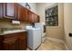 Laundry room includes washer, dryer, cabinets, utility sink, and window at 11856 Vinci Dr, Windermere, FL 34786