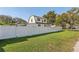 Spacious backyard with well-maintained lawn, white fence, and mature trees at 1205 Wisconsin Ave, St Cloud, FL 34769