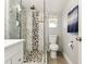 Updated bathroom with a glass-enclosed shower, decorative tile accents, and modern fixtures at 1205 Wisconsin Ave, St Cloud, FL 34769