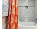 Beautiful bathroom with patterned tile accent, bathtub and bright shower curtain at 1205 Wisconsin Ave, St Cloud, FL 34769
