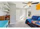 Bedroom featuring a daybed with blue bedding, a window, and a view of the doors at 1205 Wisconsin Ave, St Cloud, FL 34769