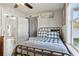 Bright bedroom offering a metal frame bed, a ceiling fan, and a sunlit window at 1205 Wisconsin Ave, St Cloud, FL 34769