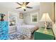 Bright bedroom with two windows and a ceiling fan, featuring floral bedding and colorful accent furniture at 1205 Wisconsin Ave, St Cloud, FL 34769