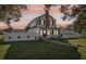 Two-story home with front yard and privacy fence, with a colorful sunset adding to the ambiance at 1205 Wisconsin Ave, St Cloud, FL 34769