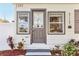 Charming front entrance features a gray-painted door, sidelight windows, and colorful landscaping at 1205 Wisconsin Ave, St Cloud, FL 34769